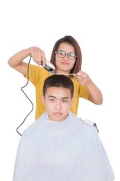teenage getting his head shaved by barber on white background
