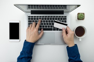 a man is going to pay for the goods in the internet using credit card and laptop computer. online shopping concept.