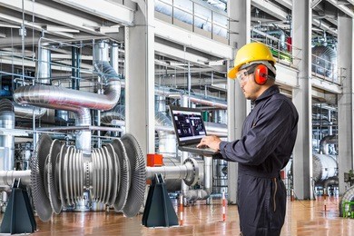 engineer using laptop computer in thermal power plant factory