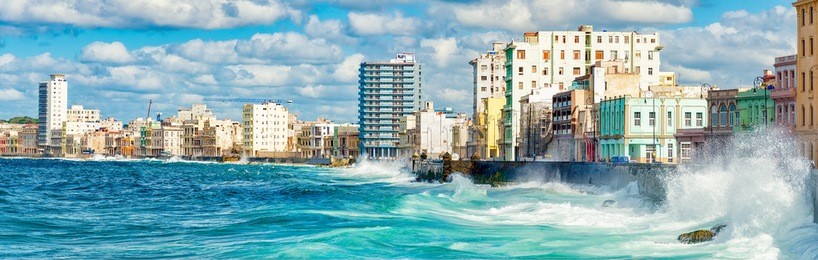 the skyline of havana with a view of sea waves crashing against the malecon wall