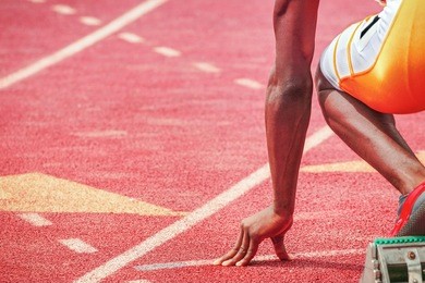 runners fingers on the starting line, ready for the start of a track and field race