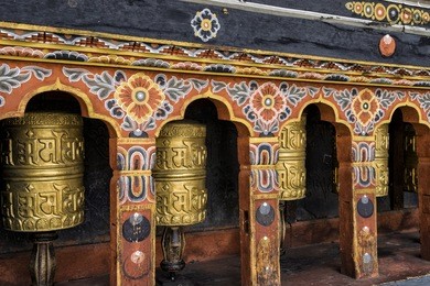 row of prayer wheels at tashichho dzong, thimphu, bhutan - the most respectful dzong in thimphu