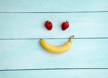 smiling face made from fruit on a wooden background