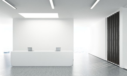 front view of concrete office lobby with laptops on white reception stand and blank wall behind. 3d rendering