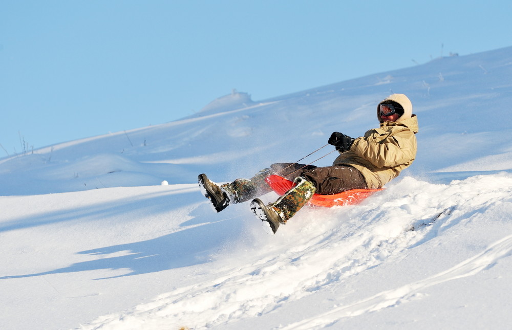 young man with sled in the snow