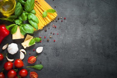 pasta ingredients. ingredients for cooking italian pasta - spaghetti, tomatoes, basil, oil and garlic. italian food. top view with space for text.