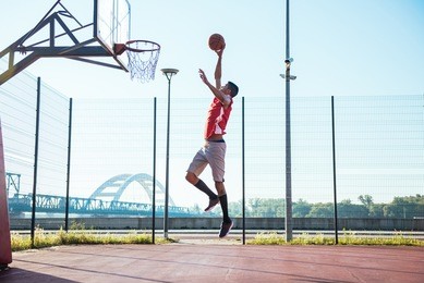 young african american basketball player scoring a slam dunk.