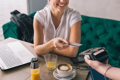 woman pay with credit card in cafe bar