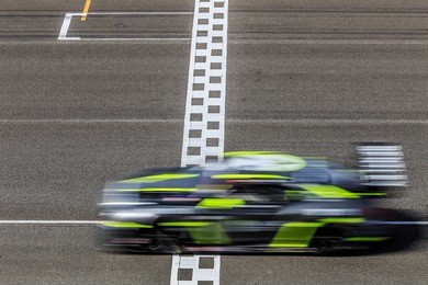 race car racing on speed track with motion blur crossing finish line