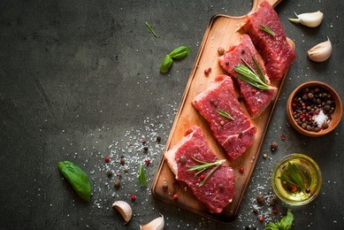 raw meat. raw beef steak on a cutting board with rosemary and spices.