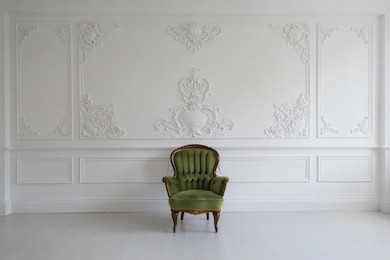 living room with antique stylish green armchair on luxury white wall design bas-relief stucco mouldings roccoco elements