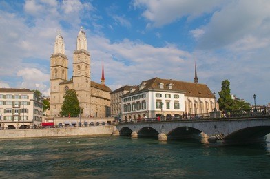 view of grossmunster church, townhall and bridge over limmat river in zurich old town, zurich, switzerland