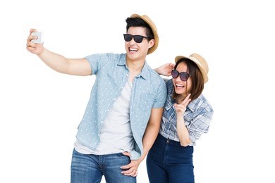 happy young couple taking a selfie on white background