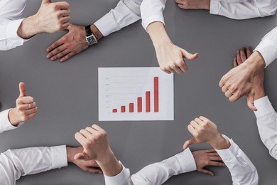 happy business team with financial report showing thumbs up