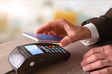 payment on a trade through mobile and nfc technology. elevated view. horizontal composition.