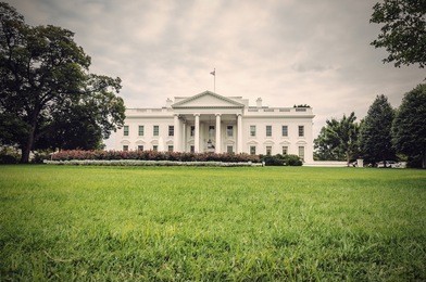 the white house in washington d.c. at a cloudy day, green lawn in foreground, executive office of the president of the united states, usa, vintage filtered style