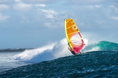 windsurfer rides among the huge tubes and waves of the indian ocean on the island of mauritius