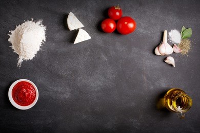 raw pizza ingredients on the chalkboard with copy space on the center. you can put your image or inscription at the center