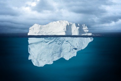 iceberg mostly underwater floating in ocean