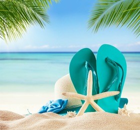 summer accessories on sandy beach, blur sea on background. summer exotic relaxation concept. copyspace for text