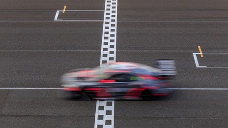 race car racing on speed track with motion blur, crossing finish line 
