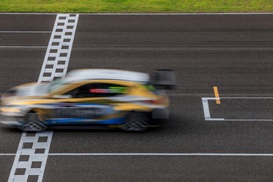 race car racing on speed track with motion blur, crossing finish line 

