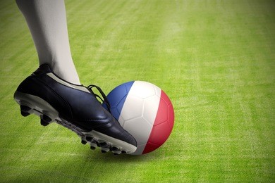 foot kicking a soccer ball with national flag of france at the