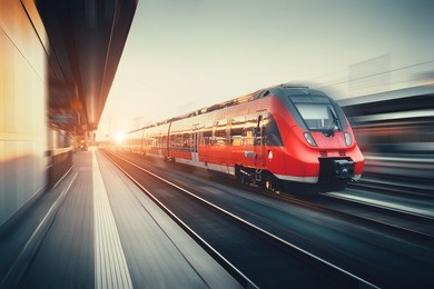beautiful railway station with modern high speed red commuter train with motion blur effect at colorful sunset in nuremberg, germany. railroad with vintage toning