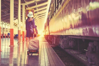 young asian tourist with luggage waiting train in railway station,vintage tone.
