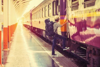 young asian tourist with luggage waiting train in station,vintage tone.
