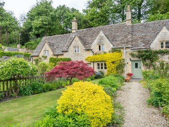 traditional stone cottages in the peaceful  cotswold village of bibury, bibury, england, under cloudy sky