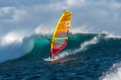 windsurfer rides among the huge tubes and waves of the indian ocean on the island of mauritius