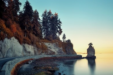 siwash rock in stanley park at sunrise in vancouver