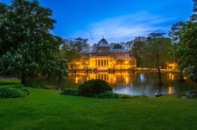 night view of crystal palace (palacio de cristal) in retiro park in madrid, spain. the buen retiro park is one of the largest parks of the city of madrid, spain