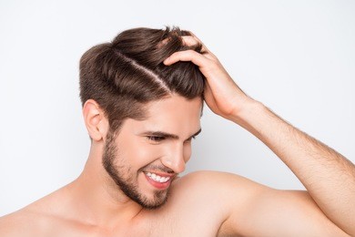 portrait of smiling man showing his healthy hair without furfur