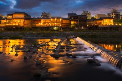 old house and restaurant in kamo river or kamogawa river at sunset, gion, kyoto, japan