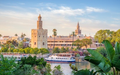 seville is divided in two by the river guadalquivir. on the east side it is located the golden tower, the cathedral and its tower called giralda.