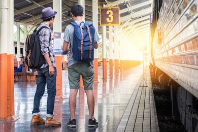 two backpackers look at a map at train station