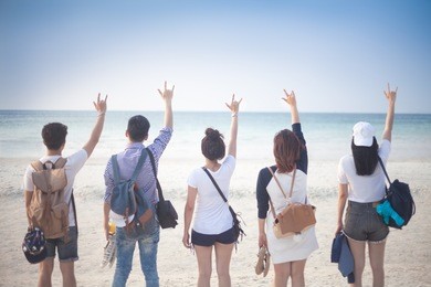 a group of five young teenager friends travel to the beach looking at the sea