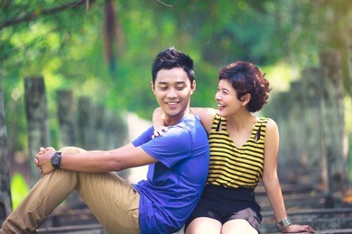happy young asian couple in love sitting on a park