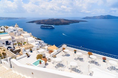 terrace with white chairs and table in firostefani village with caldera sea view, santorini island, greece