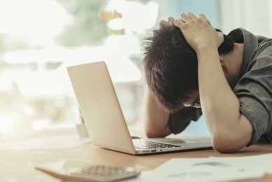 young businessman with a problem at the office  sitting at his desk with laptop