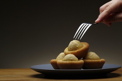 photo of a hand holding a fork about to poke a freshly baked
