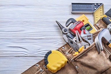 building tooling in tool belt on wooden board construction concept.