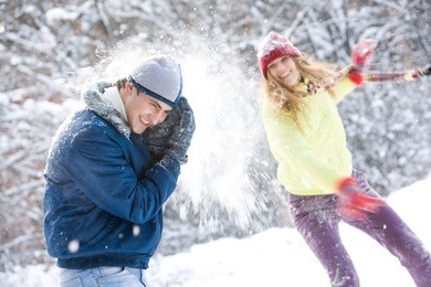 image of young woman flinging the snowball into her boyfriend