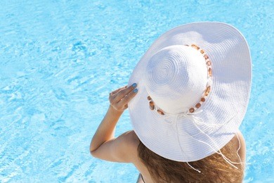 young woman sitting on the ledge of the pool
