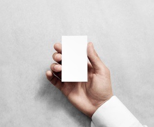 hand holding blank vertical white business name card mock up. 