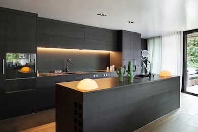 modern kitchen with black furniture and wooden floor