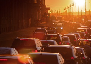 cars are in a traffic jam during a beautiful golden sunset in a big city.