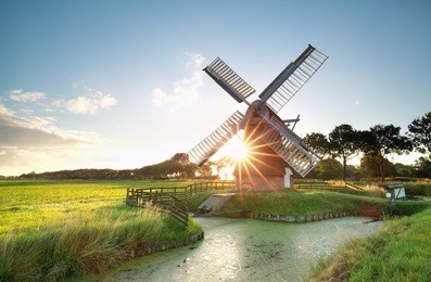 sunshine behind dutch windmill, groningen, netherlands